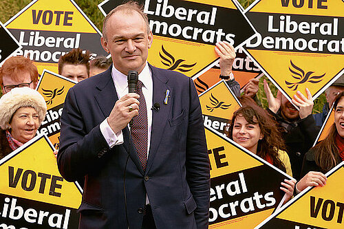 Ed Davey standing infront of a group of supporters holding vote Lib Dem diamonds